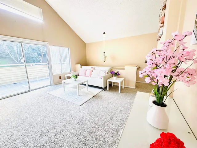 a dining room with stainless steel appliances kitchen island granite countertop a table chairs and a refrigerator