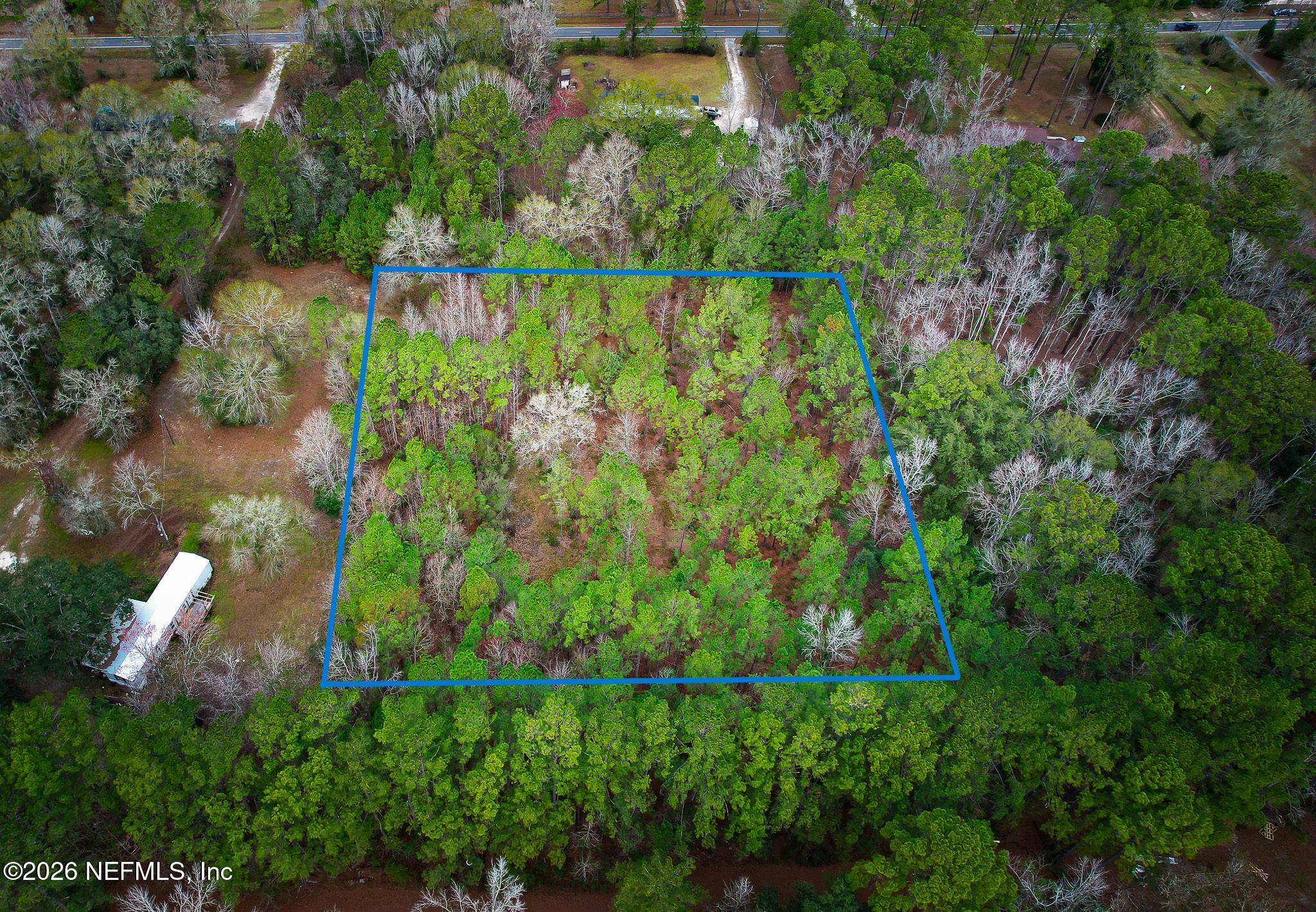 27 Ratliff Road Callahan, FL 32011 - Photo 2 of 21 an aerial view of a house with a yard and large trees