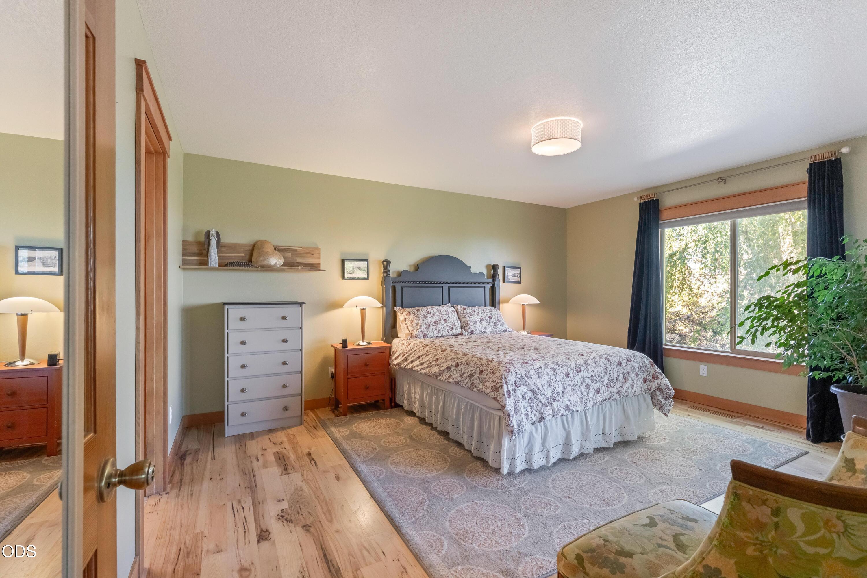 13753 South Sego Lily Road Powell Butte, OR 97753 - Photo 11 of 46 a bedroom with a bed and large windows
