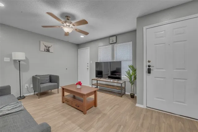 a living room with furniture and a wooden floor
