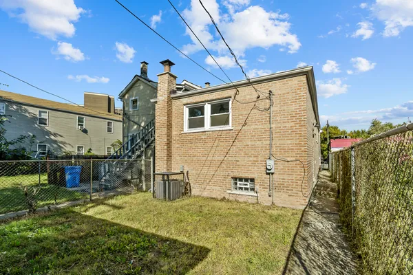 a backyard of a house with table and chairs
