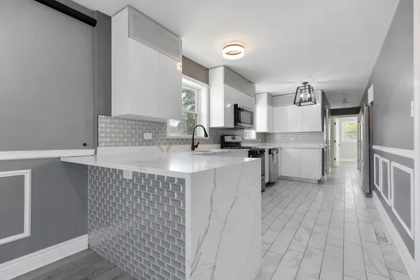 a kitchen with a sink cabinets stainless steel appliances and a window