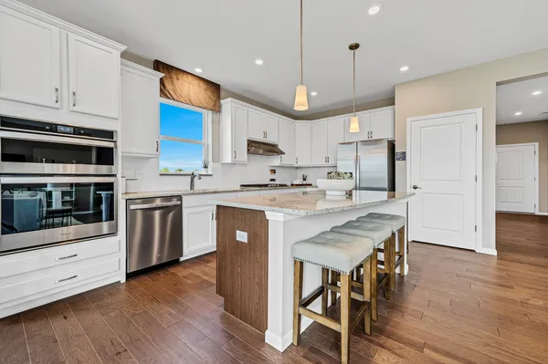a kitchen with stainless steel appliances a stove a sink a refrigerator and a microwave