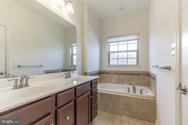 a bathroom with a bathtub sink and mirror