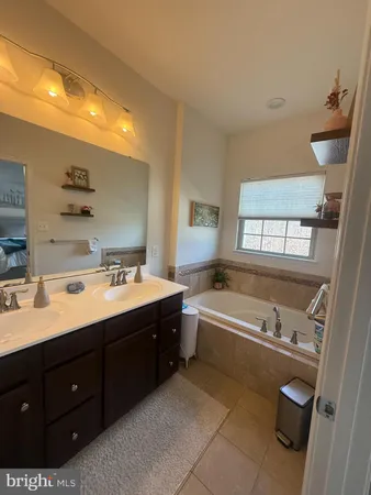 a spacious bathroom with a tub sink and mirror
