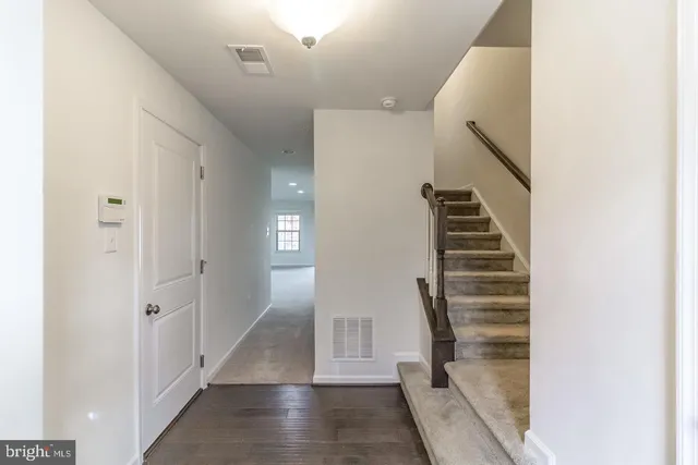 a view of a hallway with wooden floor and entryway