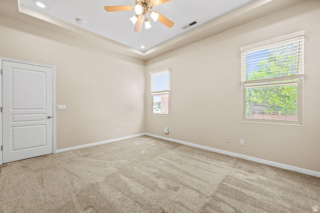 2226 East 140 South St. George, UT 84790 - Photo 15 of 20 Recessed lighting in a tray ceiling, ceiling fan, neutral carpet flooring, two windows with blinds, and white panel door