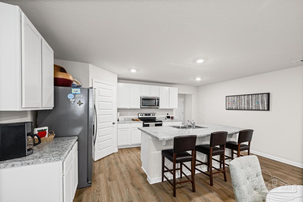 5443 Peach Drive Pace, FL 32571 - Photo 14 of 34 a kitchen with stainless steel appliances kitchen island granite countertop a sink and cabinets