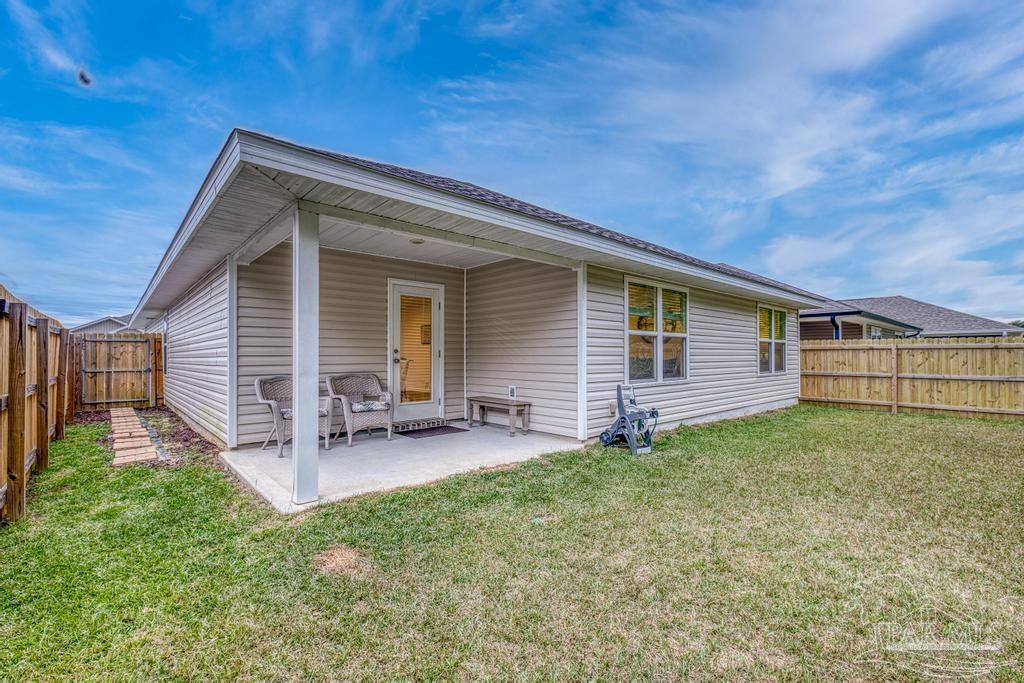 5443 Peach Drive Pace, FL 32571 - Photo 31 of 34 a view of a house with a yard and sitting area