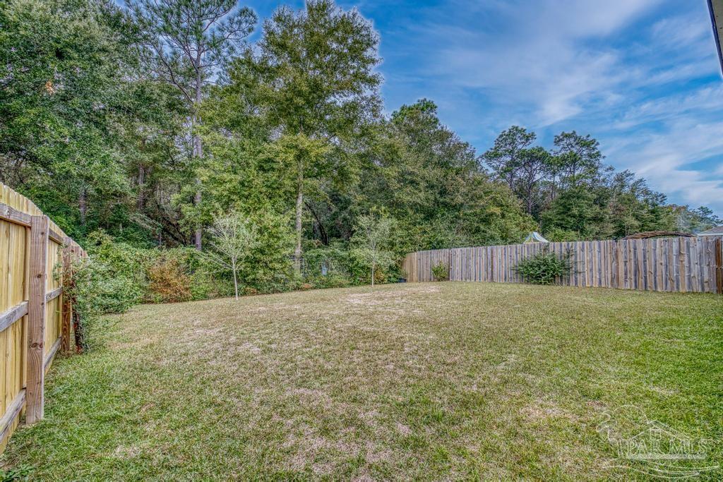 5443 Peach Drive Pace, FL 32571 - Photo 33 of 34 a backyard of a house with lots of green space