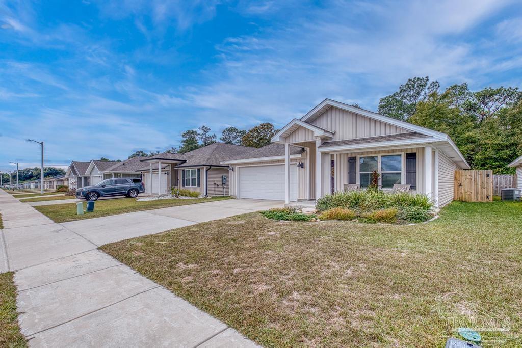 5443 Peach Drive Pace, FL 32571 - Photo 5 of 34 a front view of a house with garden