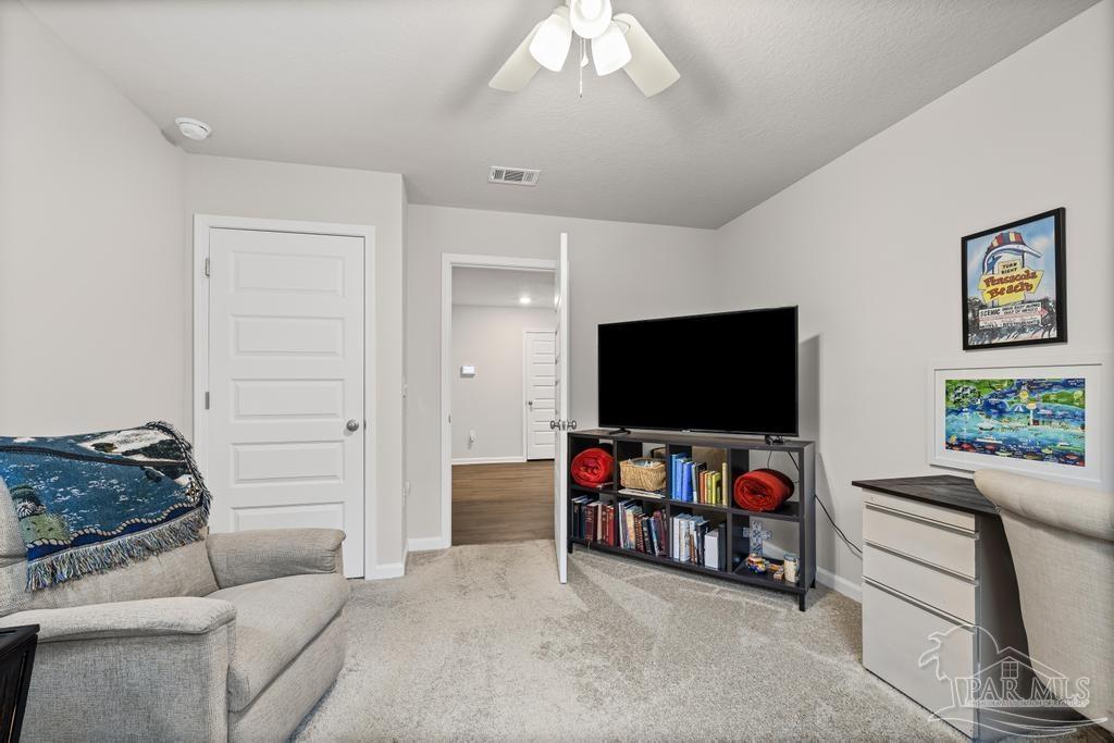 5443 Peach Drive Pace, FL 32571 - Photo 10 of 34 a living room with furniture and a flat screen tv