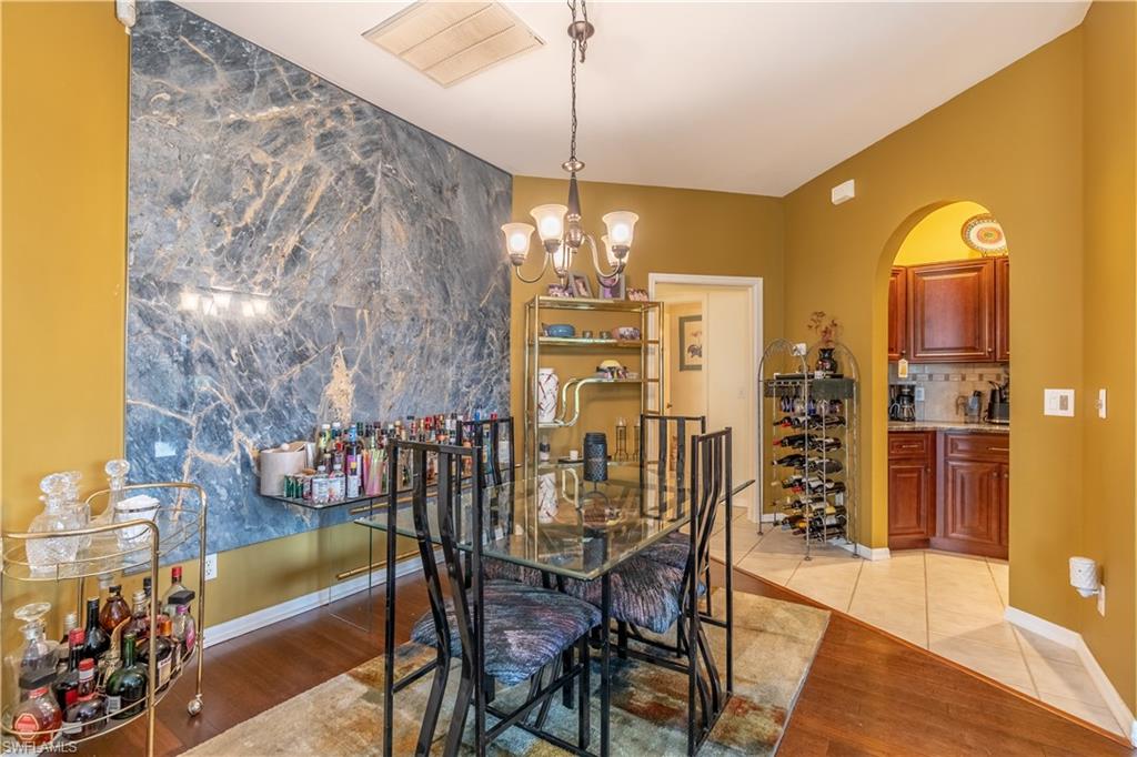 431 Crossfield Circle, Unit 77 Naples, FL 34104 - Photo 11 of 33 a view of a dining room with furniture and chandelier