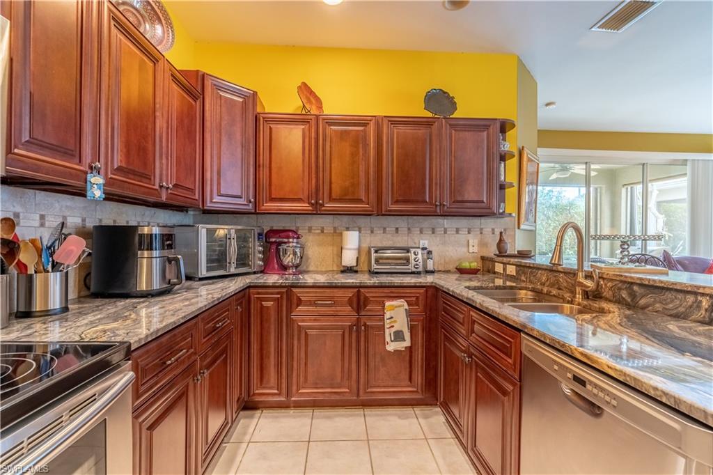 431 Crossfield Circle, Unit 77 Naples, FL 34104 - Photo 13 of 33 a kitchen with stainless steel appliances granite countertop a sink and cabinets