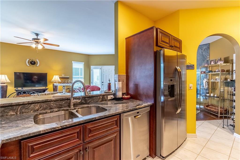 431 Crossfield Circle, Unit 77 Naples, FL 34104 - Photo 15 of 33 a kitchen with stainless steel appliances granite countertop a sink and a refrigerator
