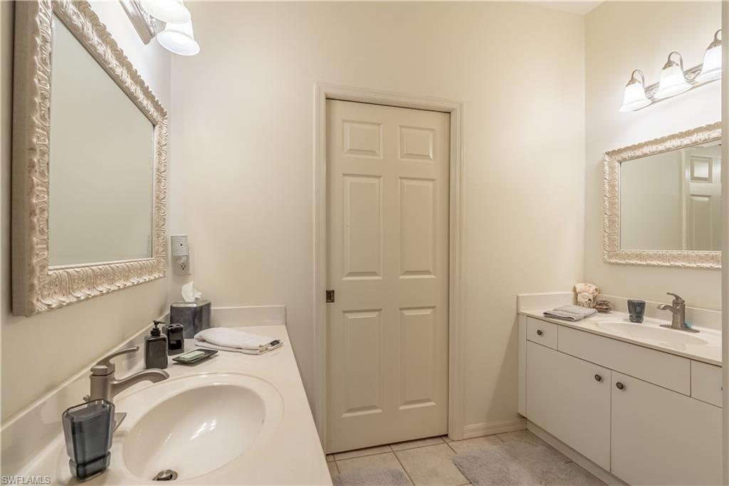 431 Crossfield Circle, Unit 77 Naples, FL 34104 - Photo 23 of 33 a bathroom with a sink and a mirror