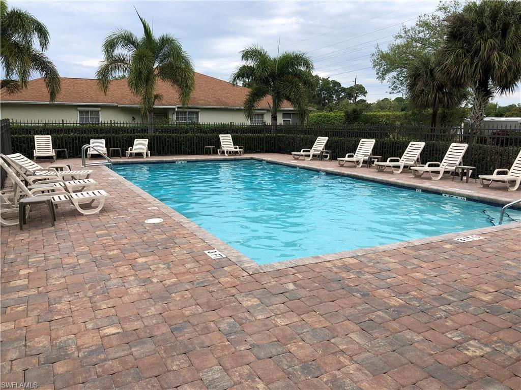 431 Crossfield Circle, Unit 77 Naples, FL 34104 - Photo 32 of 33 a view of a swimming pool with lounge chairs on th patio