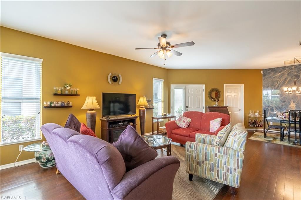 431 Crossfield Circle, Unit 77 Naples, FL 34104 - Photo 9 of 33 a living room with furniture flat screen tv and wooden floor