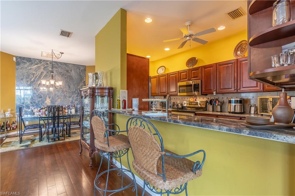 431 Crossfield Circle, Unit 77 Naples, FL 34104 - Photo 10 of 33 a dining room with furniture and wooden floor