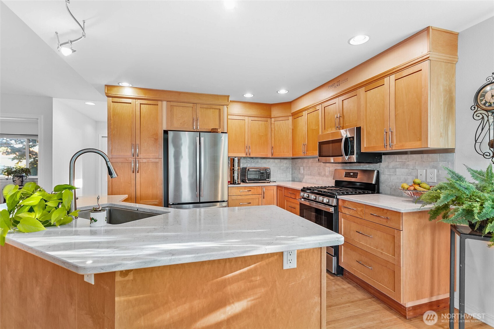 8137 Cowichan Road Blaine, WA 98230 - Photo 9 of 40 a kitchen with stainless steel appliances granite countertop a sink a stove a refrigerator a stove top oven with a dining table and chairs