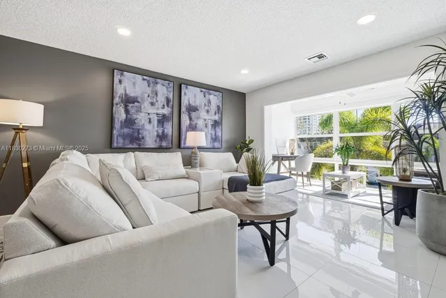 a living room with furniture potted plant and a large window