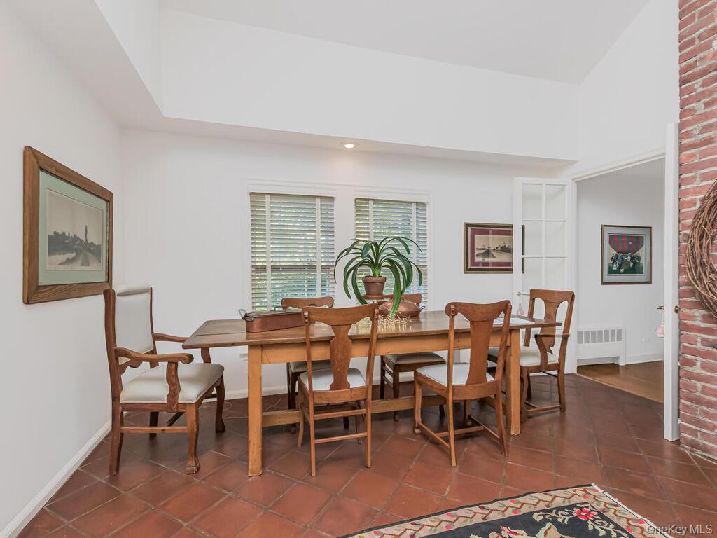 105 Douglas Road Chappaqua, NY 10514 - Photo 13 of 33 Dining space with lofted ceiling, dark tile patterned flooring, and radiator