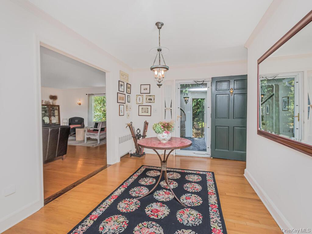 105 Douglas Road Chappaqua, NY 10514 - Photo 3 of 33 Foyer entrance with light wood finished floors, a chandelier, and radiator