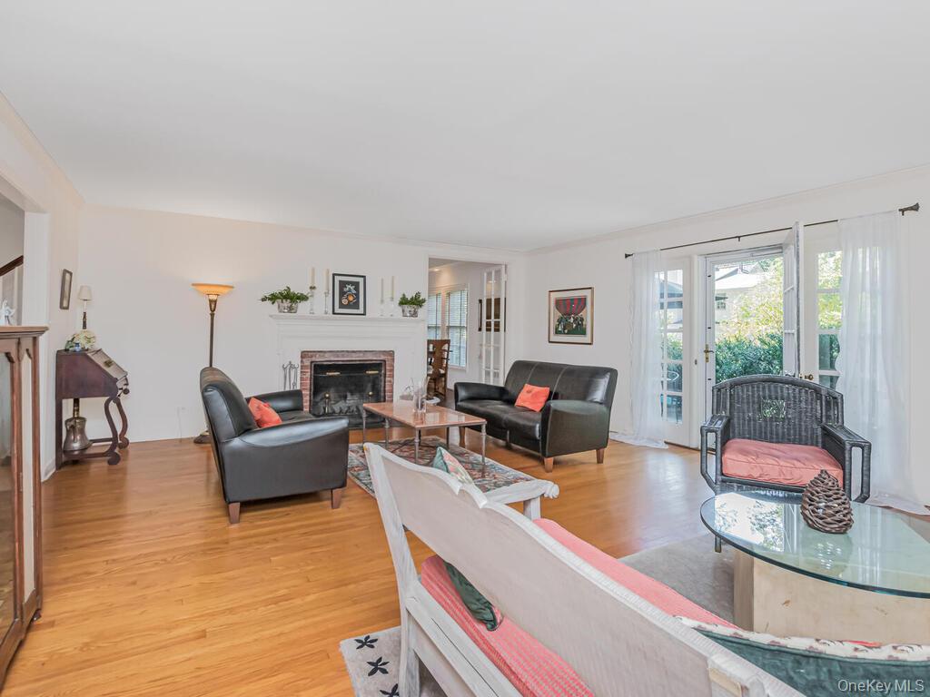 105 Douglas Road Chappaqua, NY 10514 - Photo 5 of 33 Living room with a brick fireplace, light wood-style floors, and ornamental molding
