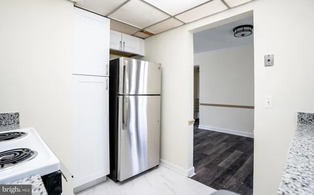 a kitchen with stainless steel appliances granite countertop white cabinets a microwave a sink and a counter