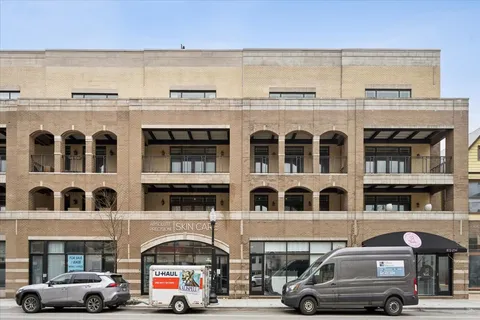a front view of building with cars parked