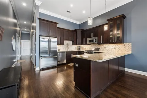 a kitchen with stainless steel appliances granite countertop a refrigerator a sink and a stove
