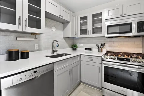 a kitchen with stainless steel appliances granite countertop a stove microwave and sink