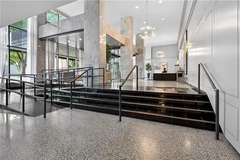 a view of hall way with mirror and furniture