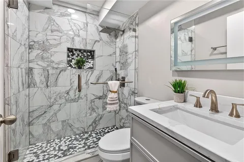 a bathroom with a sink a toilet and shower