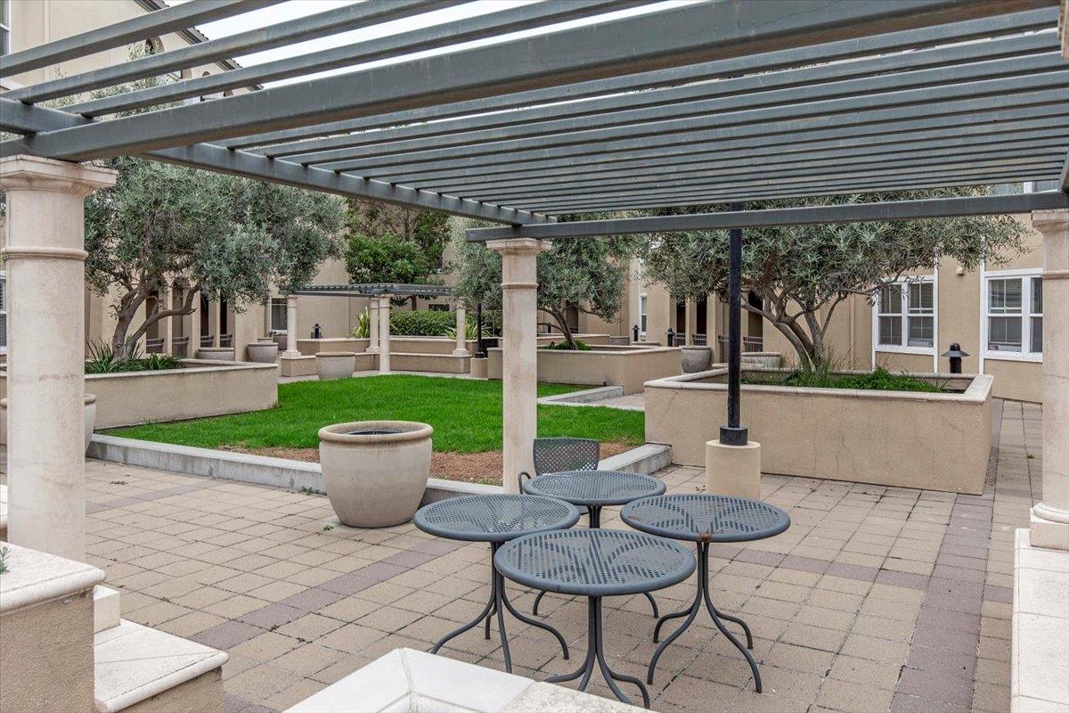 1883 Agnew Road, Unit 341 Santa Clara, CA 95054 - Photo 24 of 38 a view of a patio with a dining table and chairs under an umbrella