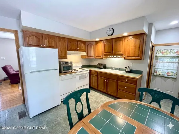 a kitchen with a refrigerator and a stove top oven