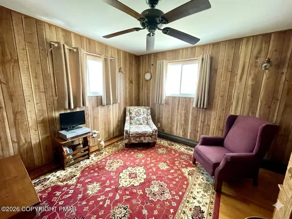 a living room with furniture a flat screen tv and a window