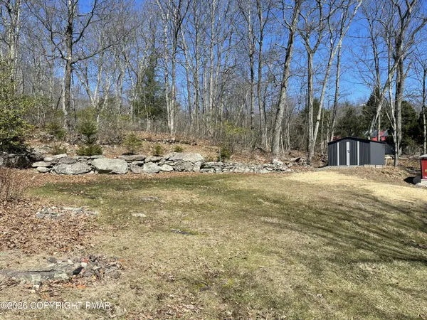 a view of a backyard with wooden fence