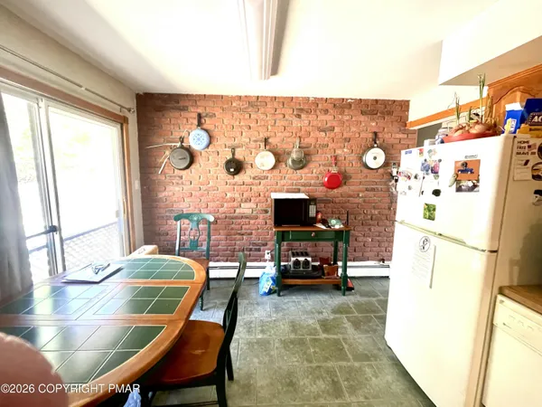 a living room with a table chairs and a refrigerator