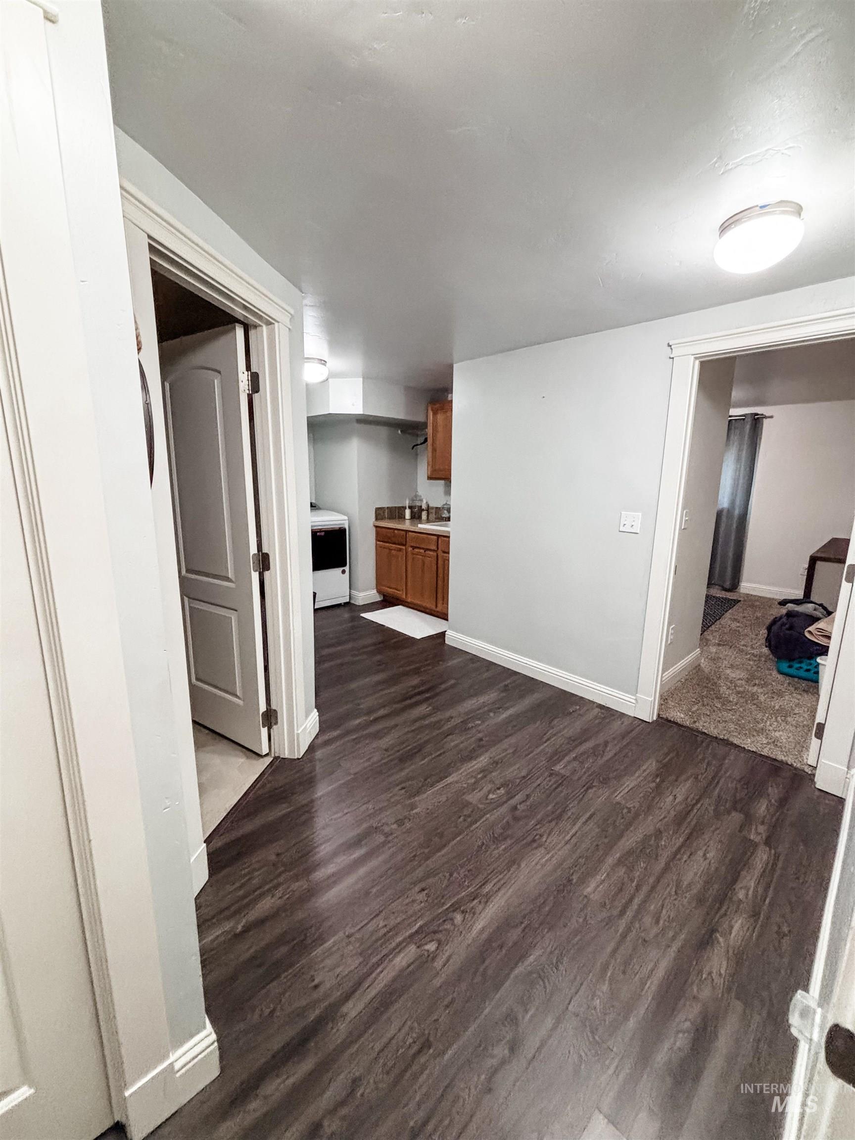 743 North Horseshoe Bend Road Eagle, ID 83616 - Photo 16 of 27 Unfurnished living room with dark wood-style flooring and baseboards