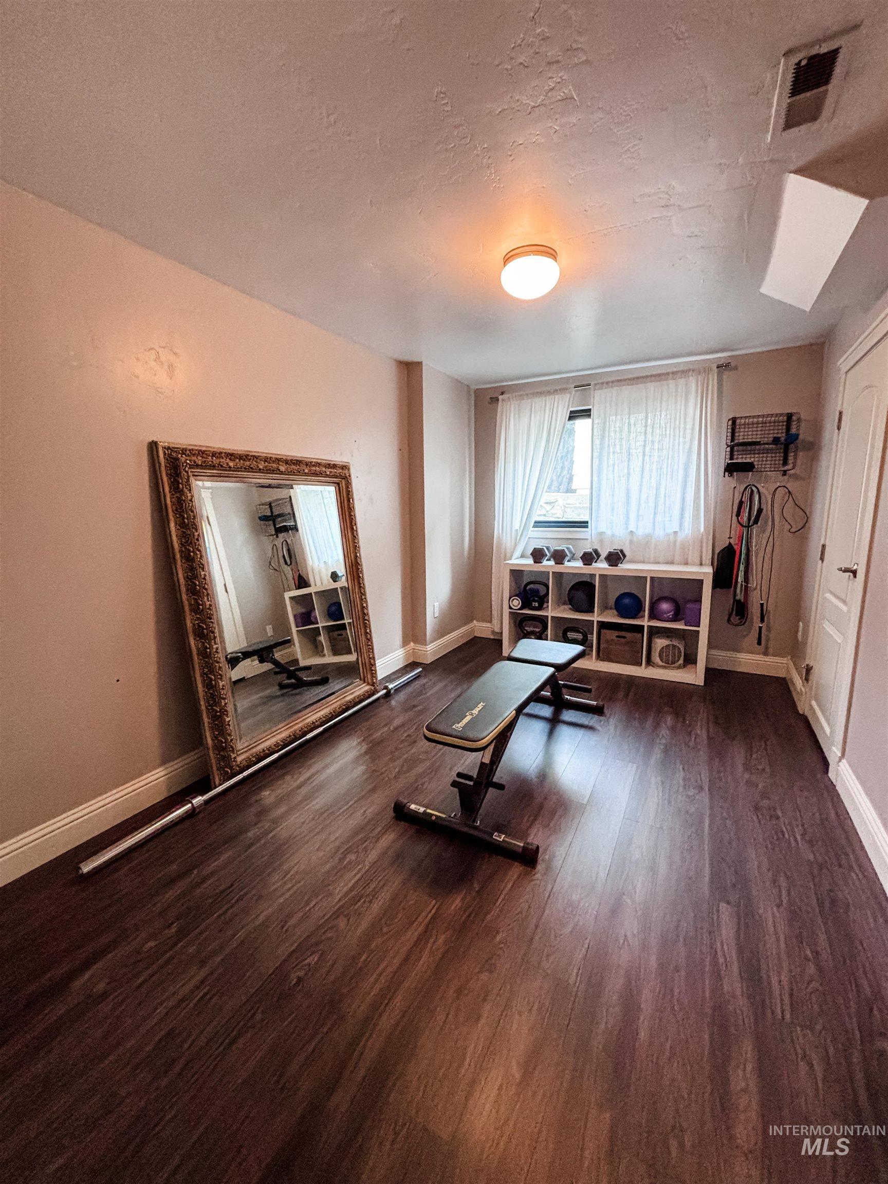 743 North Horseshoe Bend Road Eagle, ID 83616 - Photo 17 of 27 Exercise area featuring a textured ceiling and dark wood-type flooring