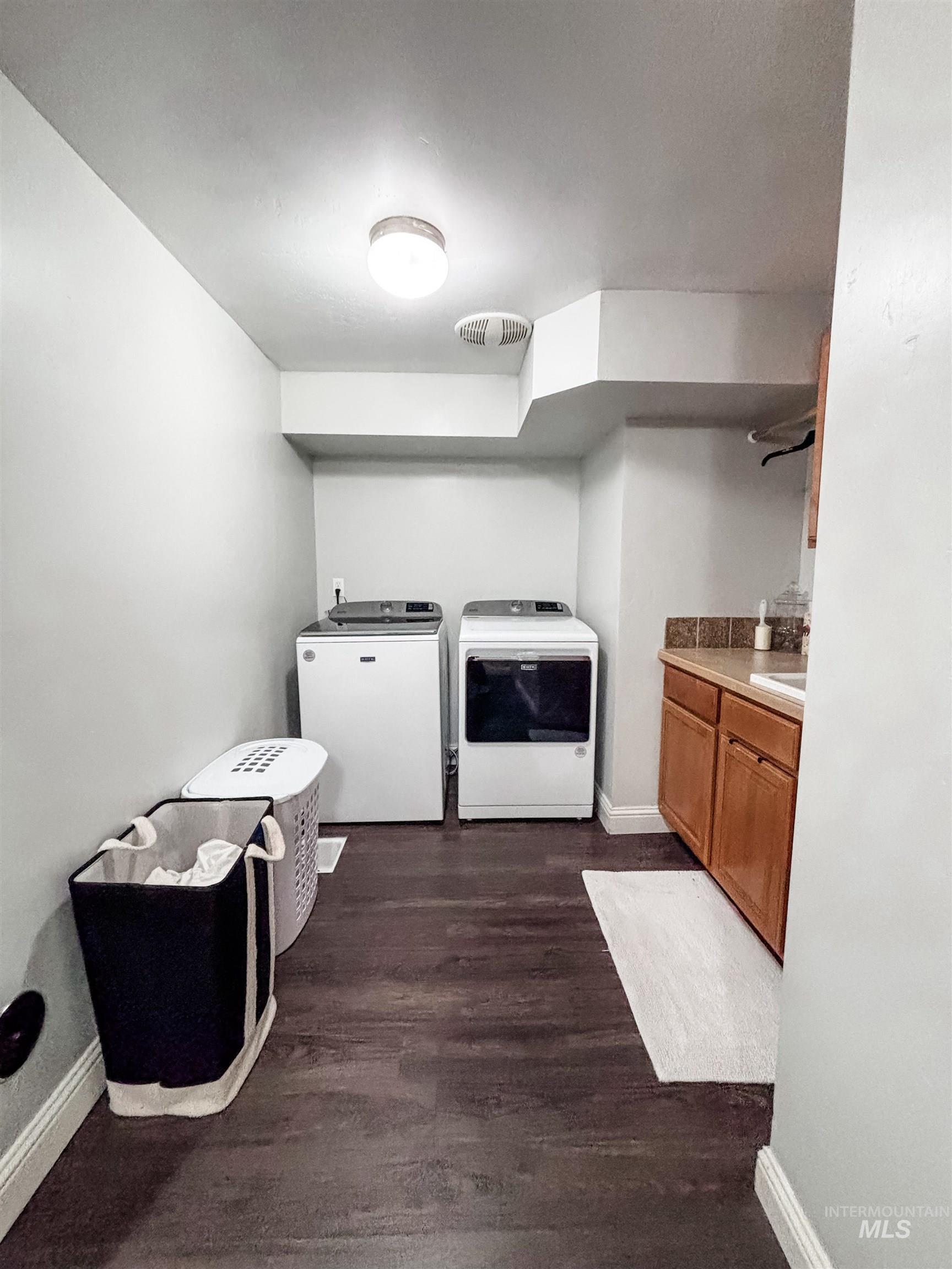 743 North Horseshoe Bend Road Eagle, ID 83616 - Photo 21 of 27 Laundry area with dark wood finished floors, independent washer and dryer, and cabinet space
