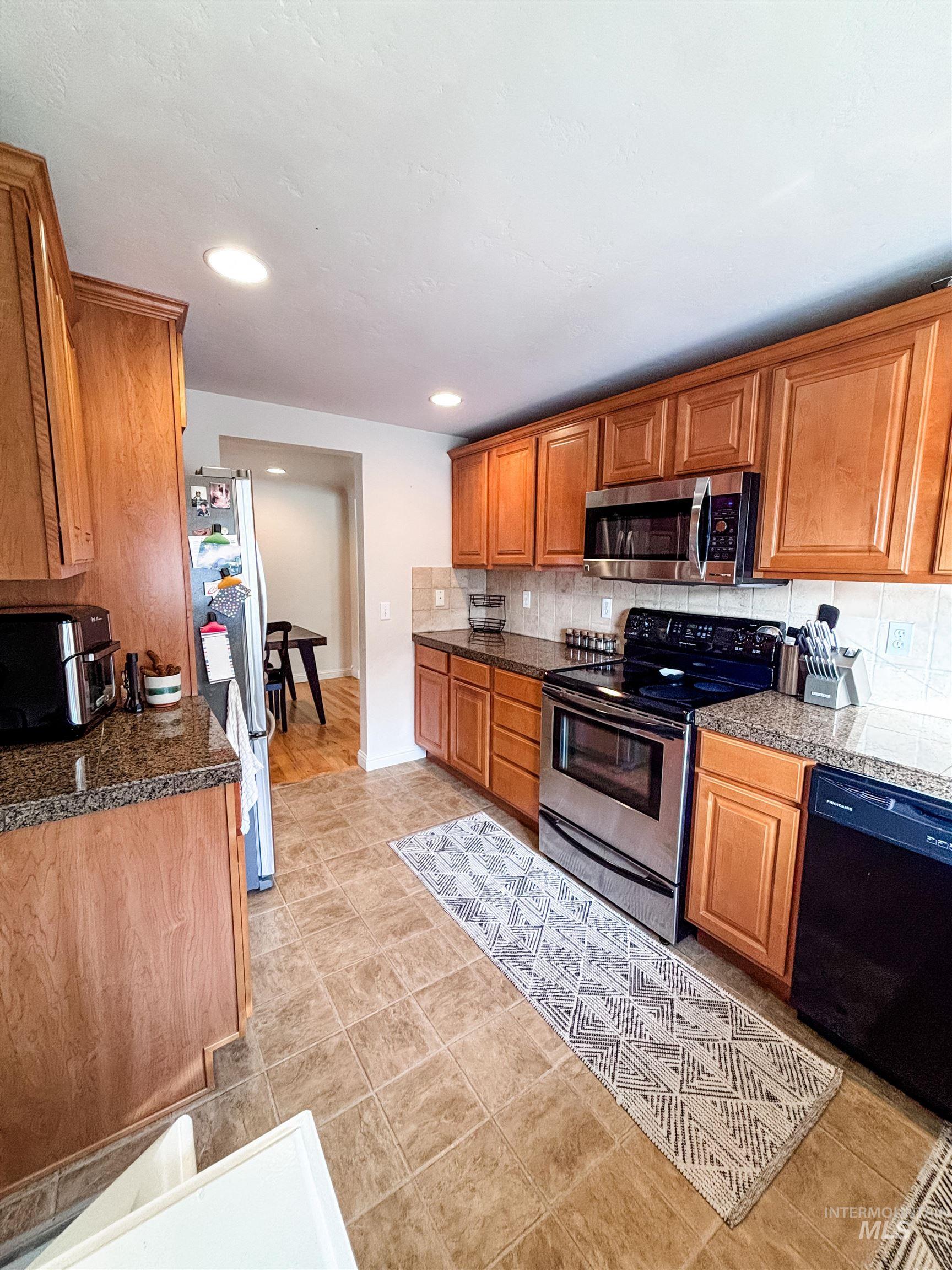 743 North Horseshoe Bend Road Eagle, ID 83616 - Photo 6 of 27 Kitchen featuring stainless steel appliances, wood finish cabinets, tasteful backsplash, and recessed lighting