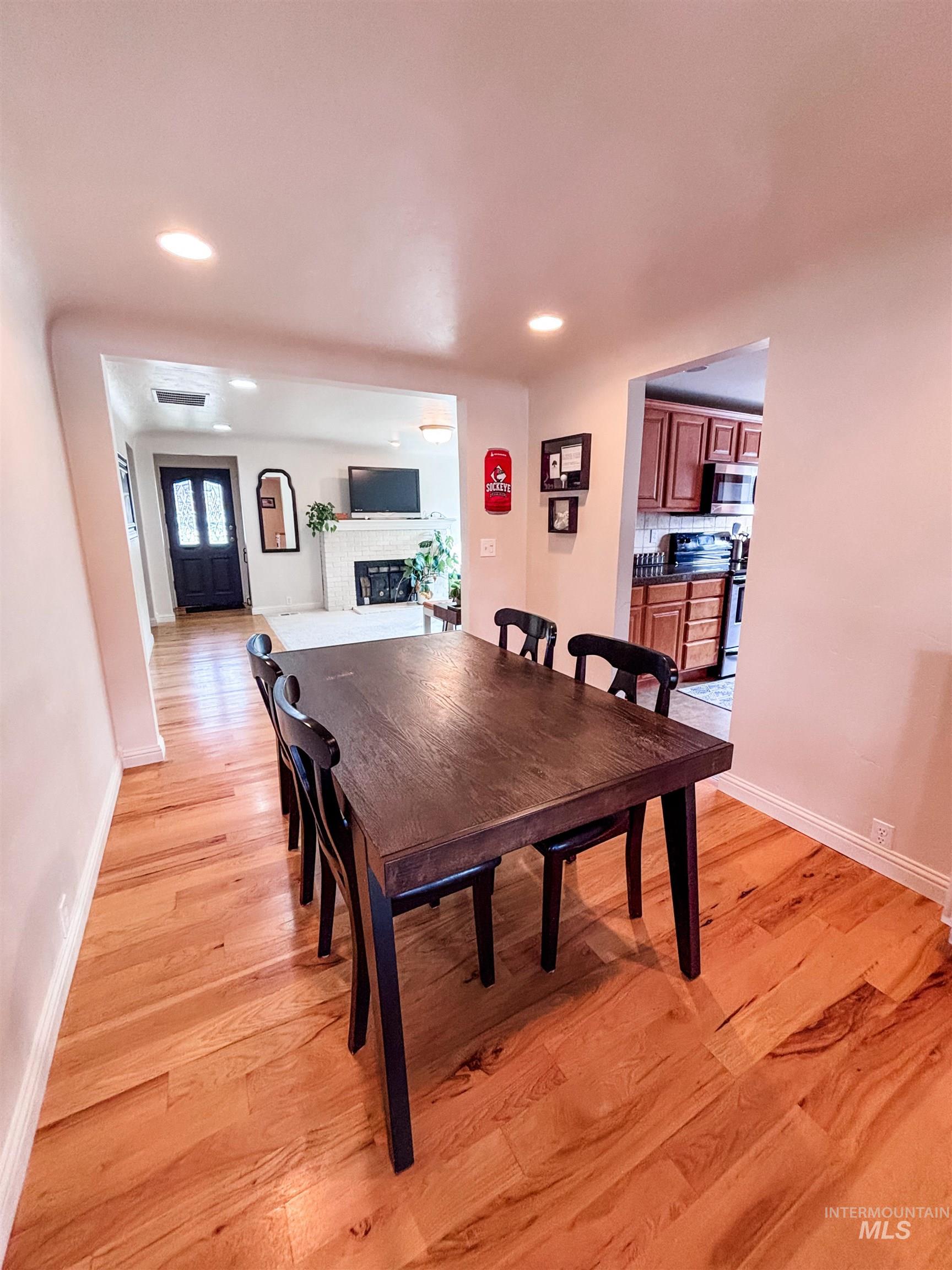 743 North Horseshoe Bend Road Eagle, ID 83616 - Photo 10 of 27 Dining space featuring light wood finished floors, a fireplace, and recessed lighting