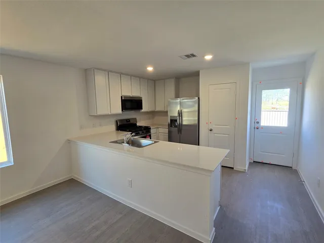 a kitchen with a refrigerator sink and wooden cabinets