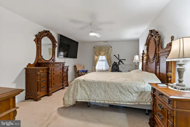 a bedroom with a bed and a flat tv screen on the dresser