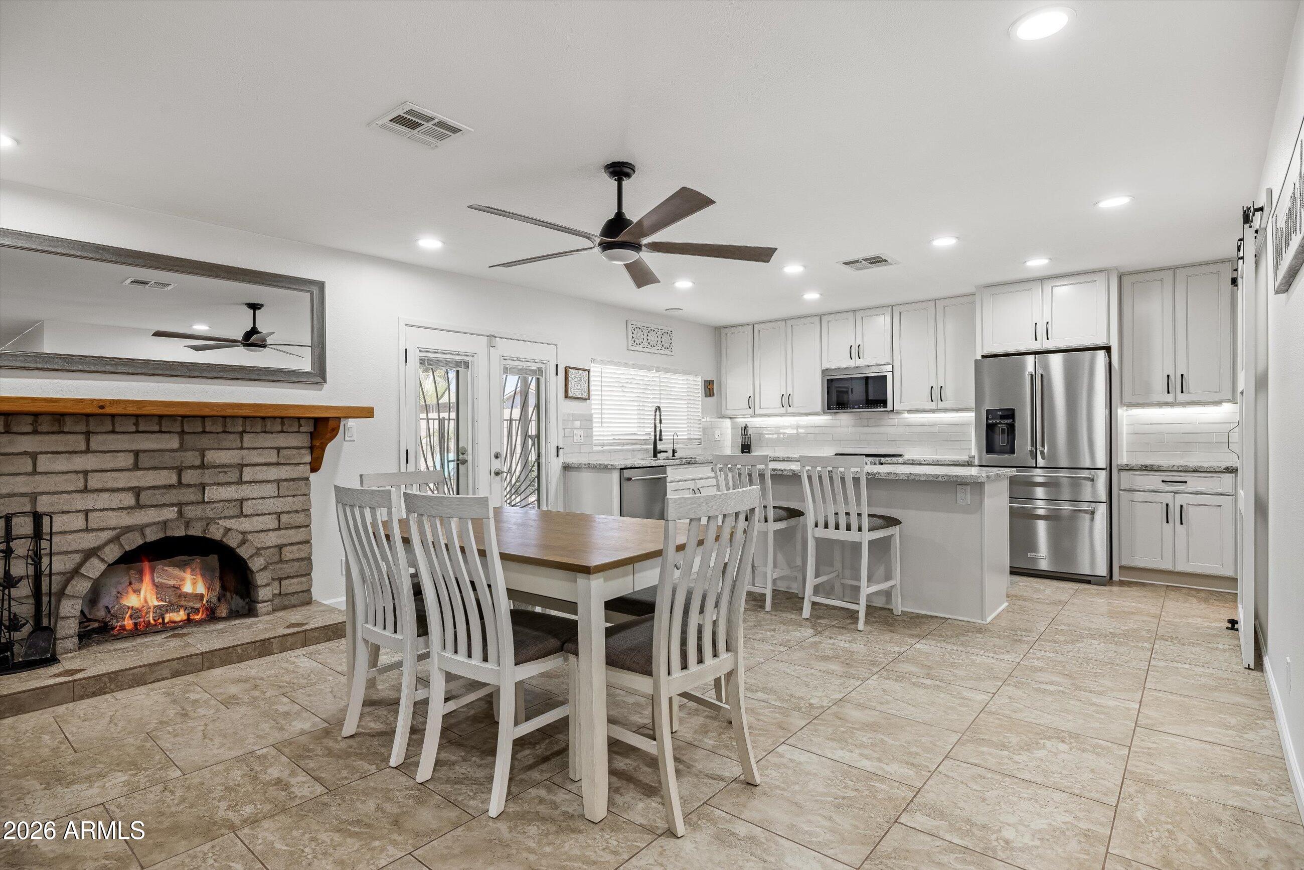 3024 West Wagoner Road Phoenix, AZ 85053 - Photo 6 of 34 a dining room with furniture a fireplace and kitchen view