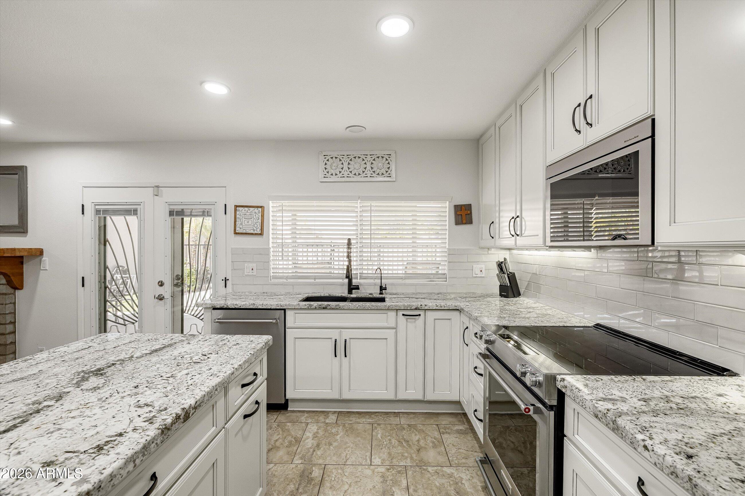 3024 West Wagoner Road Phoenix, AZ 85053 - Photo 8 of 34 a kitchen with a sink stove top oven and cabinets