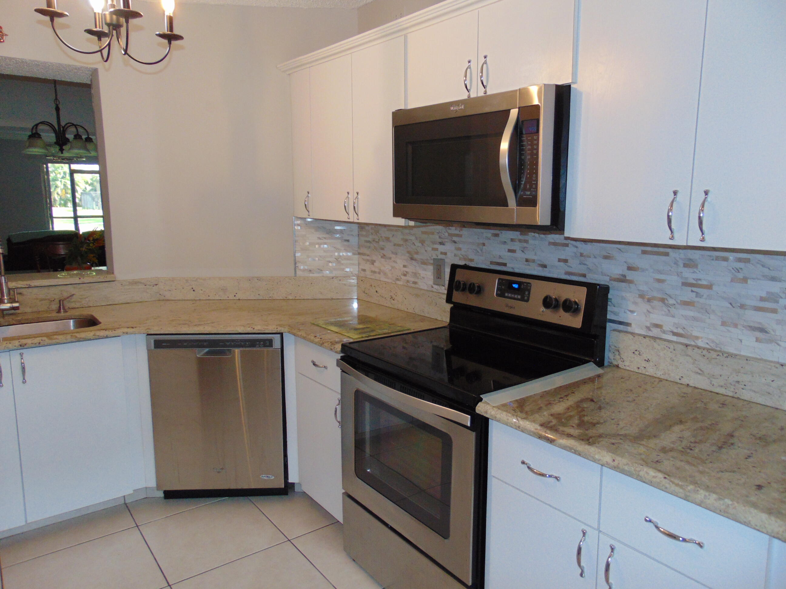 9220 Southwest 14th Street, Unit 3103 Boca Raton, FL 33428 - Photo 4 of 58 a kitchen with granite countertop white cabinets and stainless steel appliances
