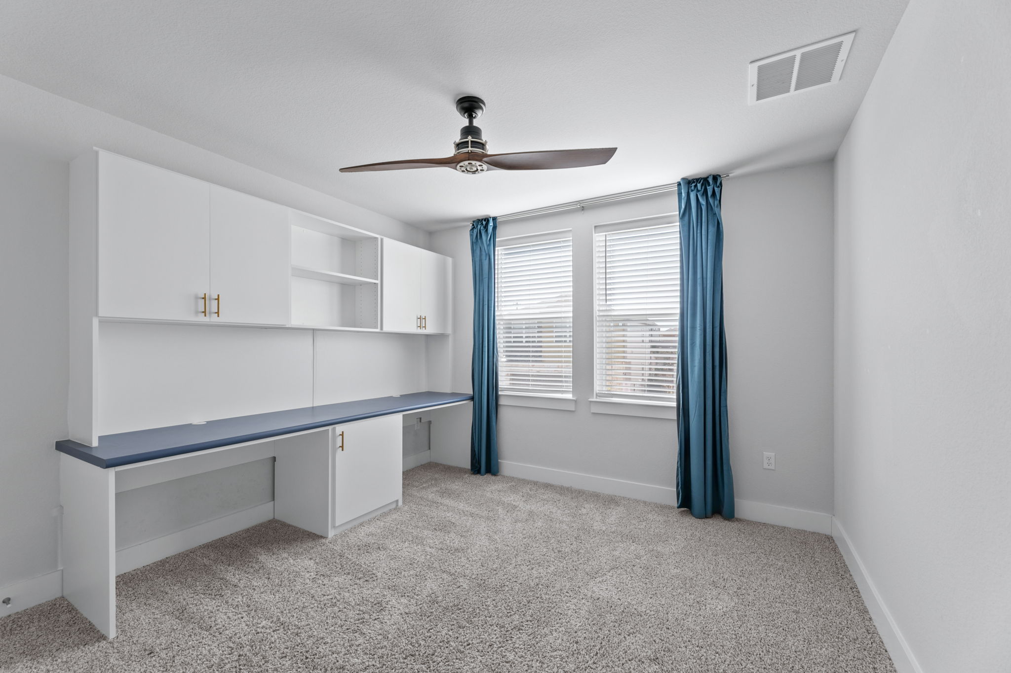 7312 Travertine Spring Drive Austin, TX 78744 - Photo 26 of 32 A versatile space features a built-in desk and shelving, perfect for a home office or creative pursuits.